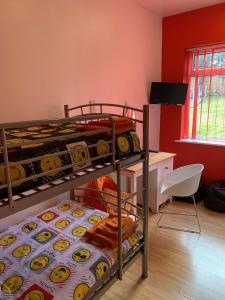 2 Etagenbetten in einem Zimmer mit einem Schreibtisch in der Unterkunft Bedrock Lodge in Bristol