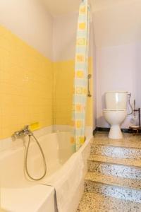 Baño amarillo con bañera y aseo en La Maréchalerie, 