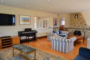 a living room with couches and a piano at Rookley Farm Lodge - Pet friendly in Rookley