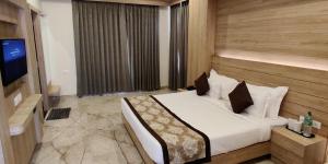 een hotelkamer met een bed en een televisie bij Hotel Lilichham in Udaipur