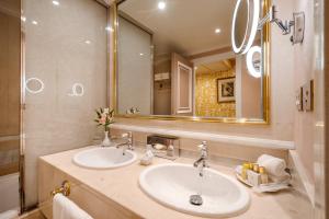a bathroom with two sinks and a large mirror at Relais & Châteaux Hotel Orfila in Madrid