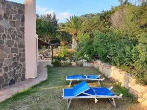 a pair of blue chairs and tables in a yard at Villa Rosetta in Chia