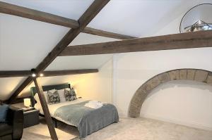 a bedroom with a bed and a vaulted ceiling at Host & Stay - The Old Workhouse in Alnwick