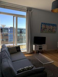 a living room with a couch and a large window at Stylish 2 Bedroom Apartment in London