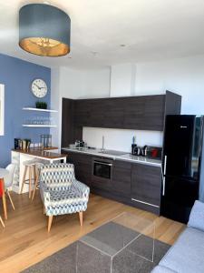 a kitchen with a black refrigerator and a table at Stylish 2 Bedroom Apartment in London