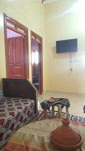 a room with a couch and a table and a door at Chez Said (Happy People) Apartment in Merzouga