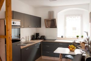 a kitchen with gray cabinets and a table and a window at FeWo 04 im Carré Charlott in Pulsnitz