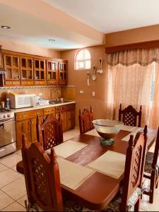 eine Küche mit einem Holztisch und einer Küche mit einer Küchenzeile im Asteroiden-Park in der Unterkunft Casa en Los Cabos, 3 recámaras in Cabo San Lucas