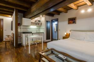 Un dormitorio con una cama blanca y una cocina. en Leoncin d'oro, en Verona 7 fotos más
