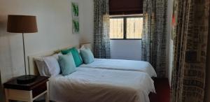 Un dormitorio con una cama con almohadas azules y una ventana en Ocean rush turtle, en Zinkwazi Beach