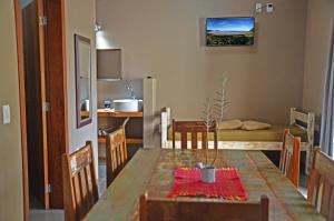 a kitchen and dining room with a table and a room at Residencial La Ferrugem - Pe na Areia in Garopaba