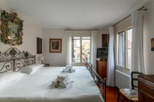 威尼斯的住宿－Ca' al Giglio - Appartamento Vista Canale，一间卧室配有一张大床,上面有两张凳子
