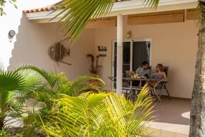 Ein Mann und eine Frau sitzen mit Laptops an einem Tisch. in der Unterkunft Hamlet Oasis Resort in Kralendijk