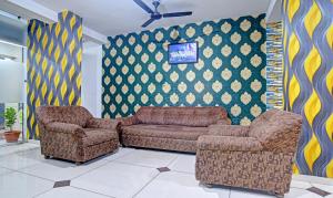 a living room with two chairs and a couch at Treebo Trend Royal Empire Indore in Indore