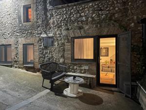 a stone building with a bench and a table at Apartament El Pou in Sant Mori