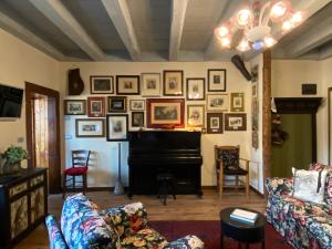 a living room with a piano and pictures on the wall at DIMORE ANTICHE in Ala