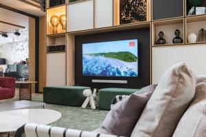 uma sala de estar com uma televisão de ecrã plano na parede em Apart-hotel YE'S Botanica em Moscou