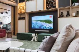a living room with a flat screen tv on a wall at Apart-hotel YE'S Botanica in Moscow