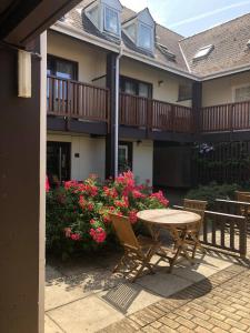 a patio with a table and chairs in front of a house at Galwad y Mor in St. Davids