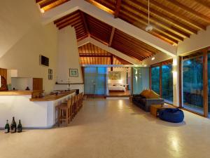een grote woonkamer met een keuken en een bank bij The Glasshouse Victoria Villa, Kandy in Digana