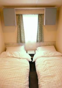En eller flere senge i et værelse på Plot 8 Lakeside Cabin, Wyldecrest, Millom