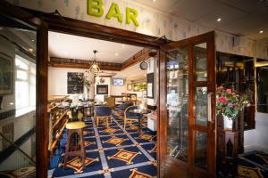 un ristorante con un bar con tavoli e sedie di Ashley Hotel a Cork