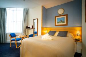 una camera d'albergo con un letto e un tavolo di Ashley Hotel a Cork