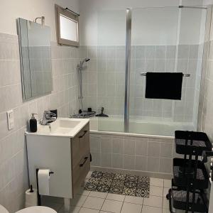 La salle de bains est pourvue d'un lavabo, d'une douche et d'une baignoire. dans l'établissement Le Marais Vous - Duplex en centre-ville., à Provins
