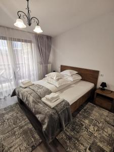 a bedroom with a bed and a large window at Rose Residence in Gura Humorului