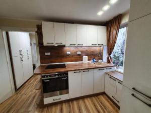 a kitchen with white cabinets and a sink and a stove at Malavi KI top center studio Ruse in Ruse