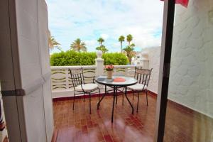 een terras met een tafel en stoelen op een balkon bij Studio with a canarian atmosphere in the south in Costa Del Silencio