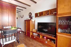 een woonkamer met een flatscreen-tv en houten kasten bij Studio with a canarian atmosphere in the south in Costa Del Silencio