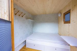 um pequeno quarto com uma cama e um tecto em madeira em CHECKIN THE BOX Schloss Neubruck em Scheibbs
