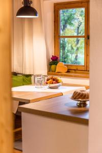 una cocina con una mesa con un bol de fruta y una ventana en Ferienwohnung Neuhaus en Kitzbühel