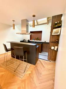 a kitchen with a black counter and chairs in it at Capella YourHostHelper in Caen