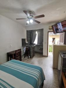 een slaapkamer met een bed en een plafondventilator bij Hotel Hortencia in Puerto Vallarta