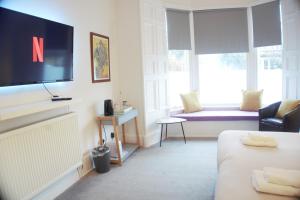 a room with a bed and a tv and a couch at Barns Serviced Accommodation in Ayr