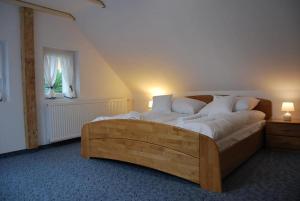 a bedroom with a large wooden bed with white pillows at Karkonoska Przystań Motocyklowa u Lisa in Chmieleń +42 photos
