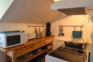 a small kitchen with a microwave and a stove at APPARTEMENT LUZ ST SAUVEUR in Luz-Saint-Sauveur