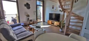 a living room with a couch and a television at Appartement 3 pièces en duplex in Antibes