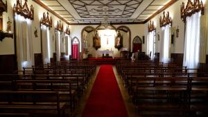 uma igreja vazia com um tapete vermelho no corredor em O Cantinho do Colégio - Dourocollege em Lamego