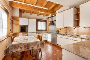 a kitchen with white cabinets and a table at Chalet Gaste Big Family in Livigno
