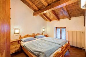 a bedroom with a large wooden bed with blue sheets at Chalet Meridiana Appartamento 9 in Livigno