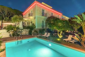 Raphael Hotel Arbatax في ارباتاكس: بيت فيه مسبح قدام بيت