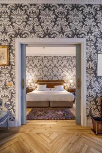 a bedroom with a bed and a wall with wallpaper at Relais & Châteaux Hotel Orfila in Madrid