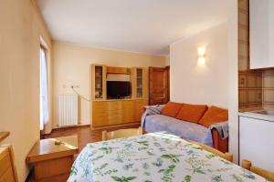 a room with a bed and a living room at Chalet Meridiana Appartamento 7 in Livigno