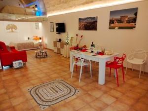 a living room with a white table and red chairs at Il Risveglio nei Sassi in Matera