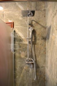 y baño con ducha y pared de piedra. en Apartment Lesser town!, en Praga