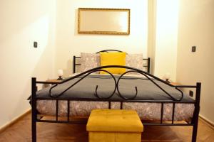 a bedroom with a black bed with a yellow stool at Apartment Lesser town! in Prague