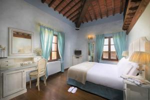 a bedroom with a bed and a desk and a bed and window at Relais la Leopoldina in Bettolle